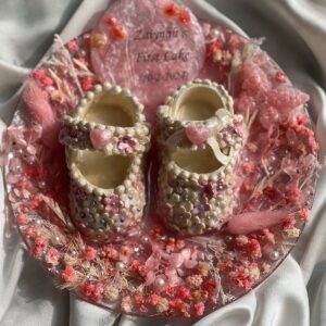 Baby’s fondant shoes from first birthday cake preserved in flowers and resin , Mustcrafts